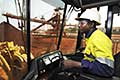 Operator of front end loader at iron ore stock pile, Sierra Leone